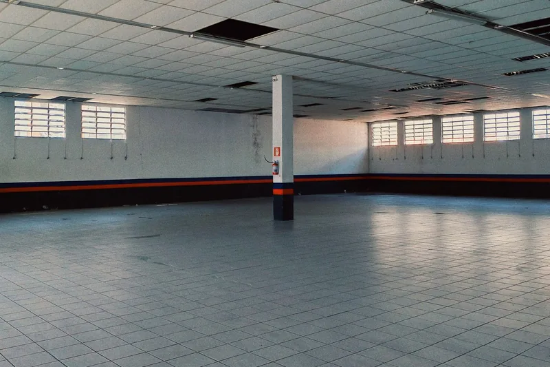 Large empty hall with tiled floor and high windows